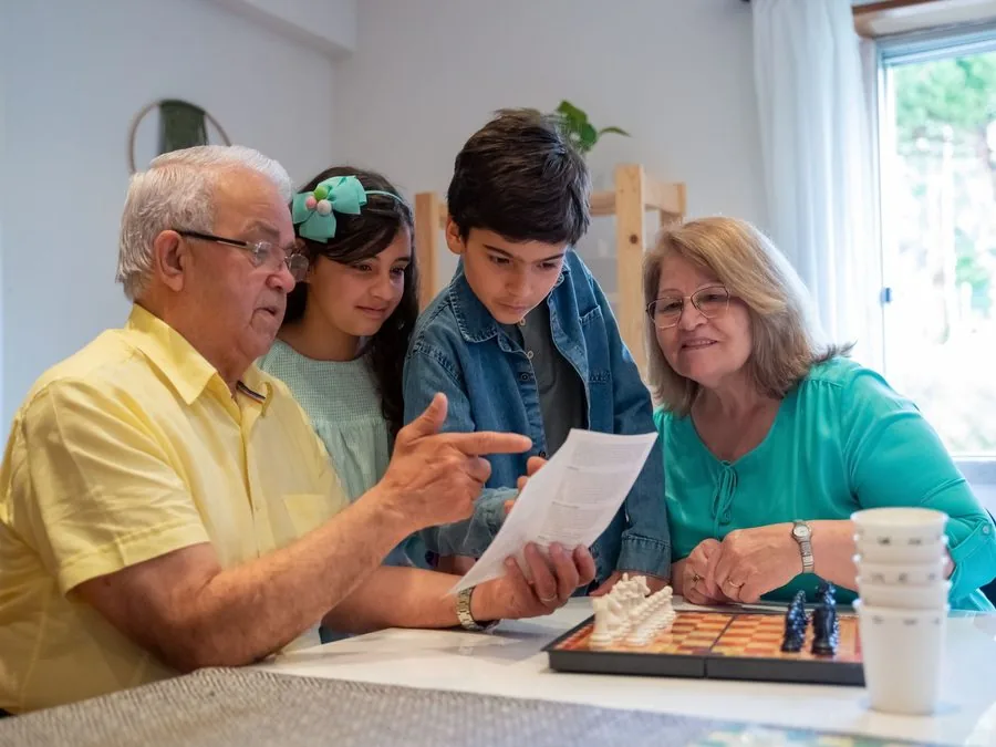 Grandparents playing chess with their grandchildren