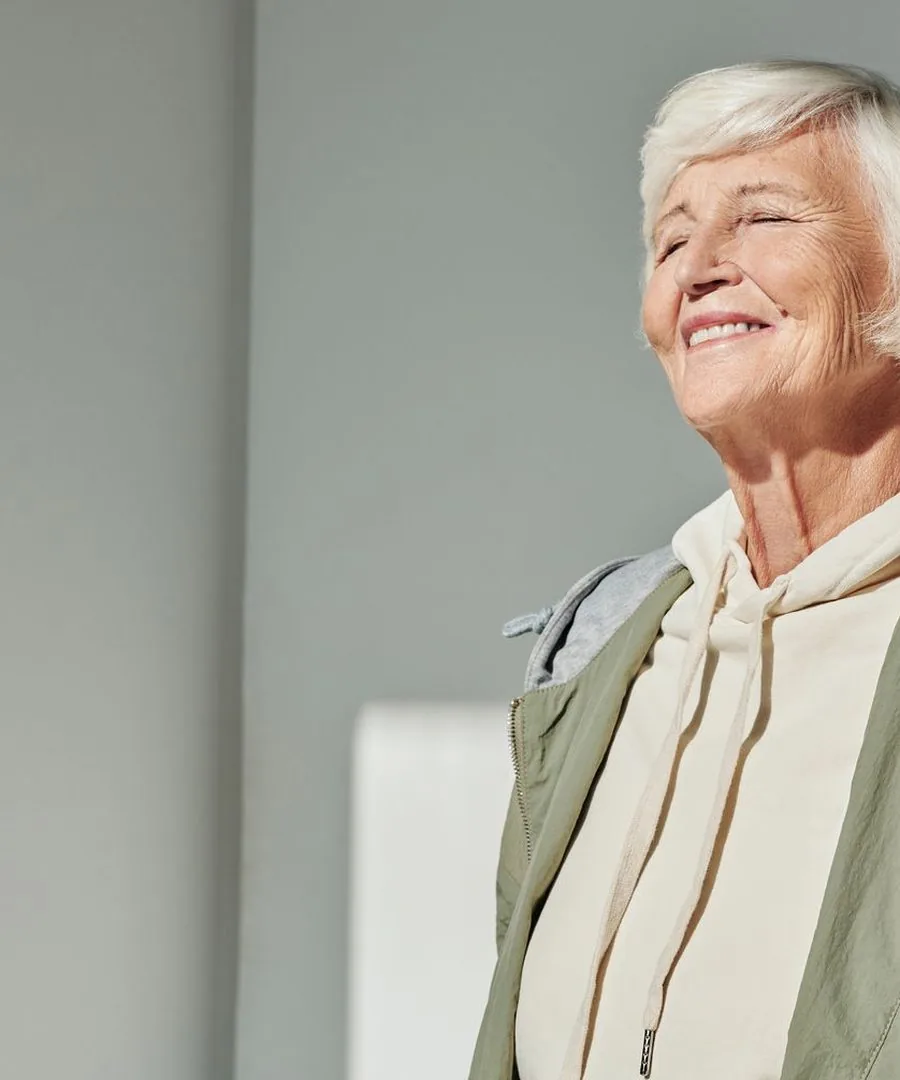 A woman with her eyes closed, enjoying the sun on her face