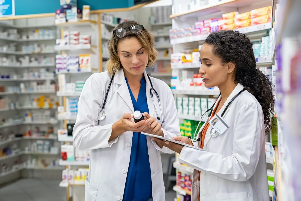 Two clinicians reviewing a recommended supplement bottle
