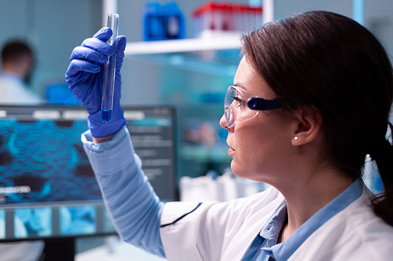 Female scientist in lab examinging a test tube